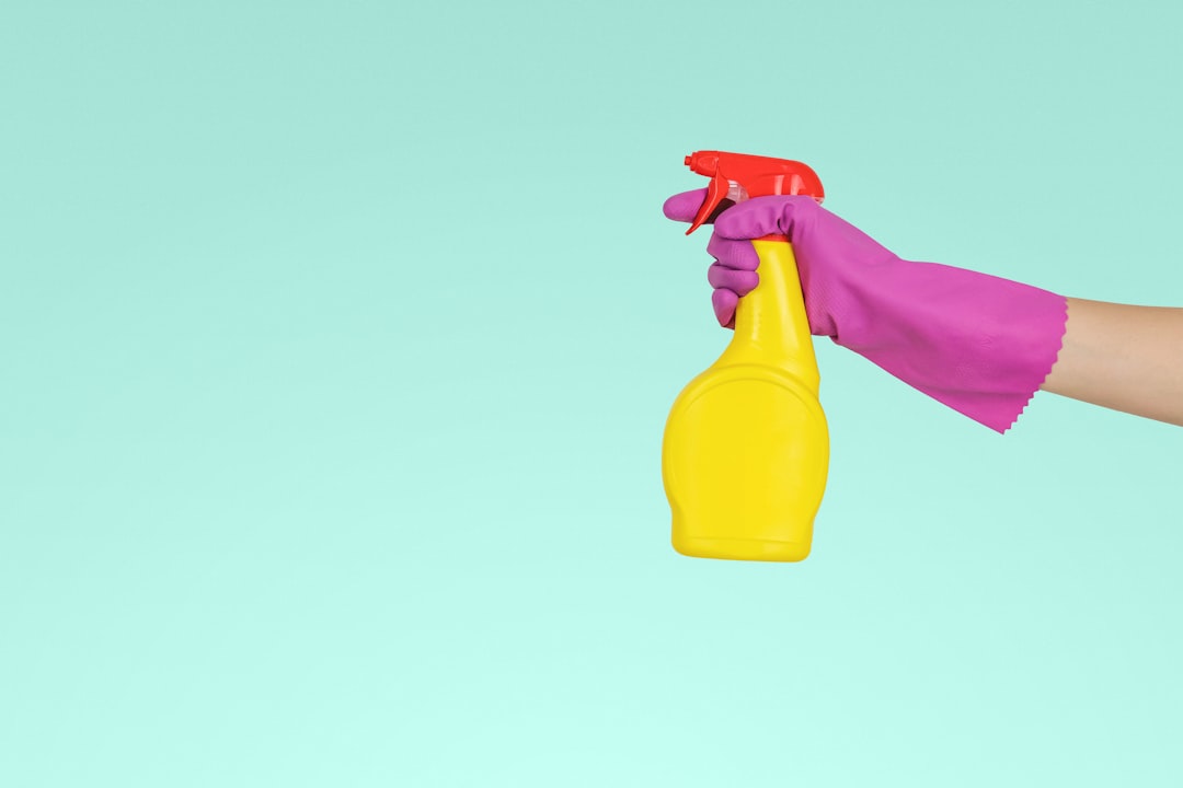 individual-grasping-yellow-plastic-spray-container-zmnefoi3k